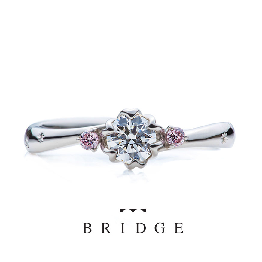 春の足音はプロポーズ用として人気の婚約指輪サイドのピンクがかわいい緩やかウェーブタイプは指長効果もあります。