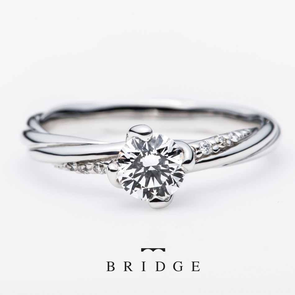  銀座で人気の結婚指輪と婚約指輪のブライダルリングのセレクトショップ、ブリッジ銀座アントワープブリリアントギャラリーが取り扱うブランド「ＢＲＩＤＧＥ」で人気のデザイン「よろこびの絆（bond precious）」しめ縄モチーフのエンゲージリング。かっこいいデザインですが、１１石連ねたダイヤモンドラインが、女性らしさも表現しており、大人の女性にぜひつけてほしいデザインです。