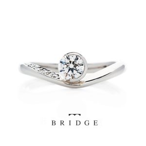 東京銀座のブリッジ限定アシンメトリーなデザインが花嫁に人気のＶラインの婚約指輪は指長効果ストレスのない表面仕上げつけ心地も抜群で女子に人気
