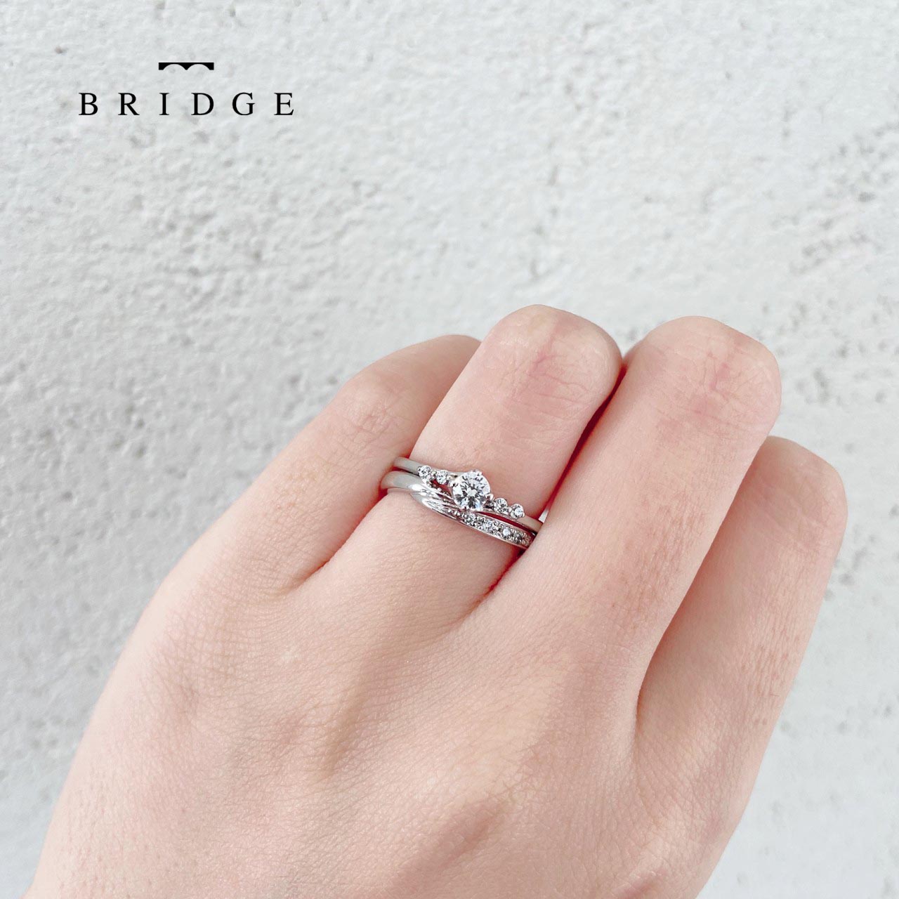 華奢なプラチナでウェーブさせた結婚指輪と婚約指輪のセットが人気ブリッジ銀座のいざないの水神セットリング。