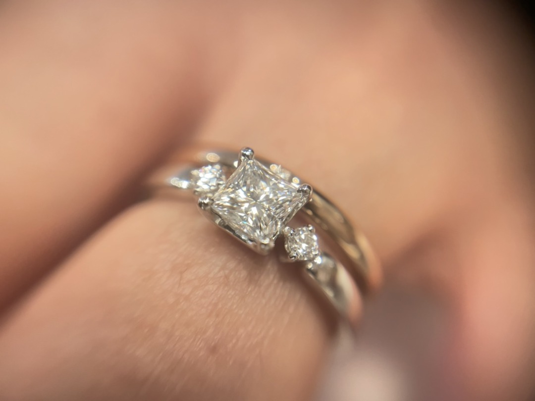 プリンセスカットをセッティングした婚約指輪と結婚指輪の重ね付けがオシャレでかわいい